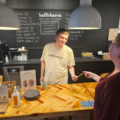 Kaffebar disk mand betjener gæst 